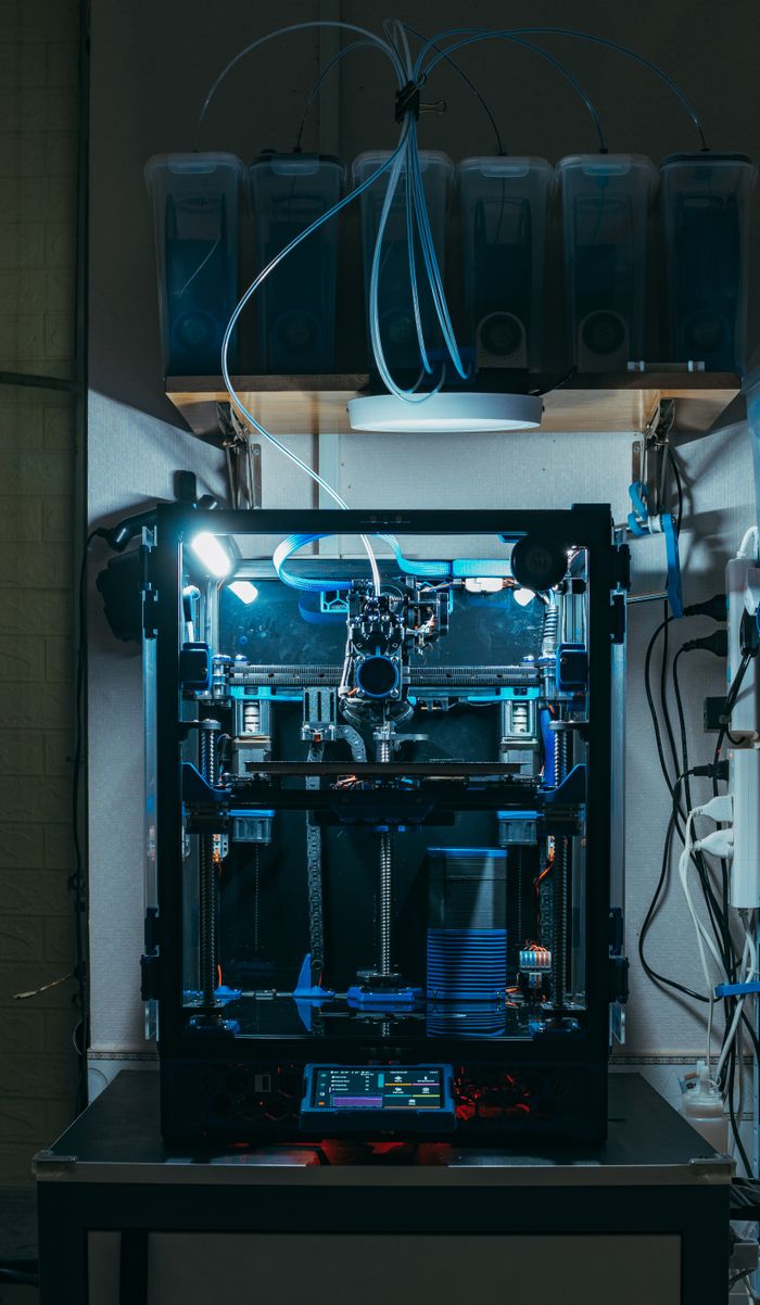 A high-tech 3D printer operating in an industrial workshop, showcasing modern technology.